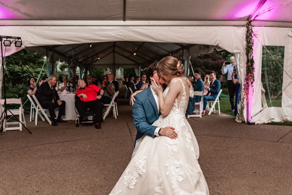 Bride and groom kissing during their first dance at a Phipps Botanical Gardens wedding reception in Pittsburgh