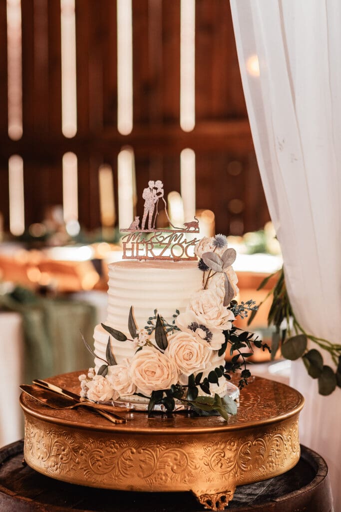 Wedding cake on gold stand with last name personalized cake topper at Pinehall at Eisler Farm