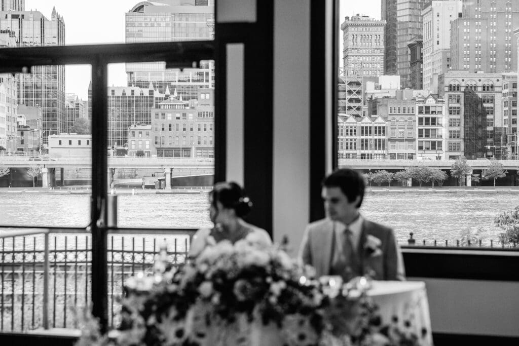 Blurred photo of wedding couple at head table with Pittsburgh city skyline in focus at Sheraton Station Square