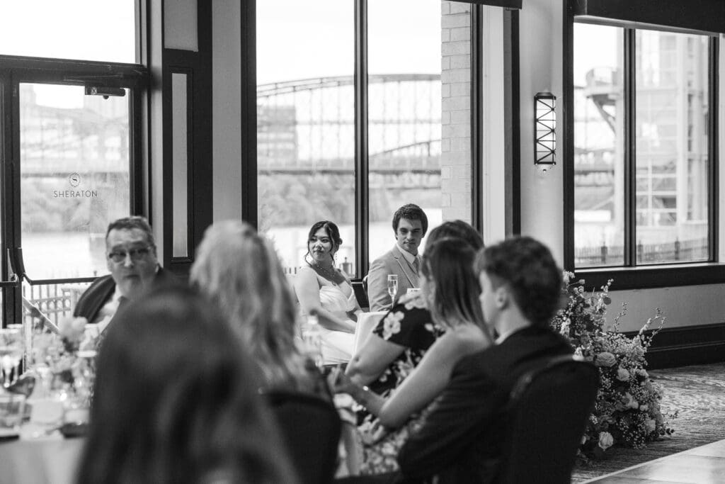 Wedding couple listens to heartfelt speeches during their Sheraton Station Square reception