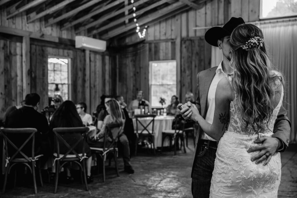Black and white wedding photos capturing intimate moments between couples inside Hinckston Run Farm barn