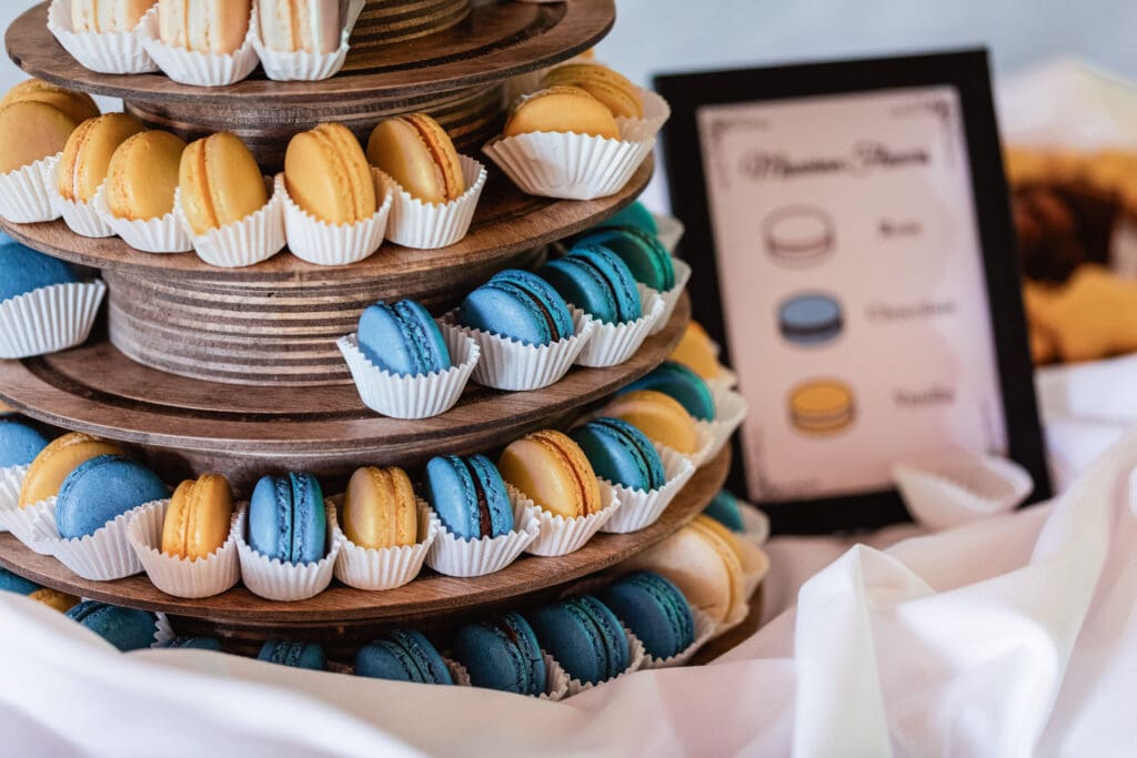 Tiered wooden display with colorful macarons in blue and beige cups at Succop Nature Park wedding