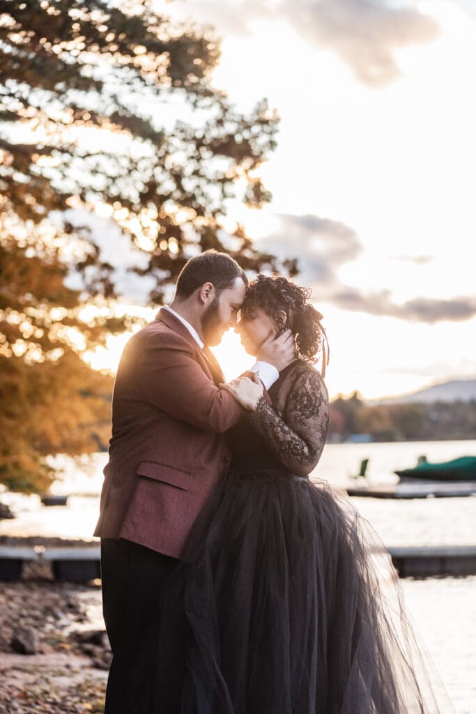 Wedding couple in dark florals and burgundy suit poses during sunset ceremony at Deep Creek