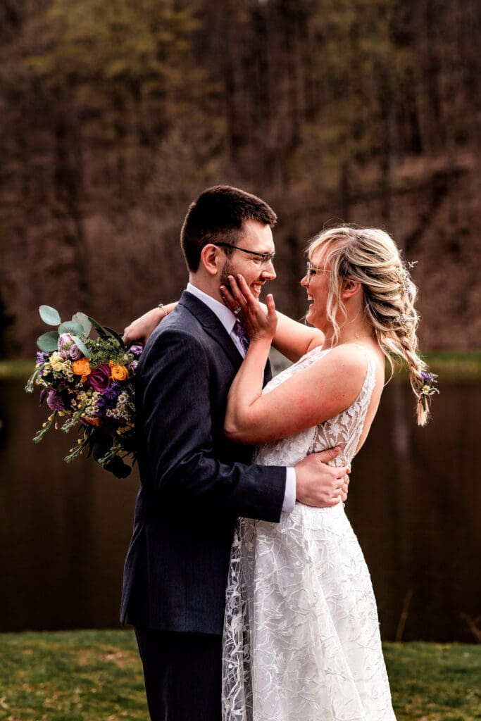 Bride and groom share an intimate moment by a lake near The Fez