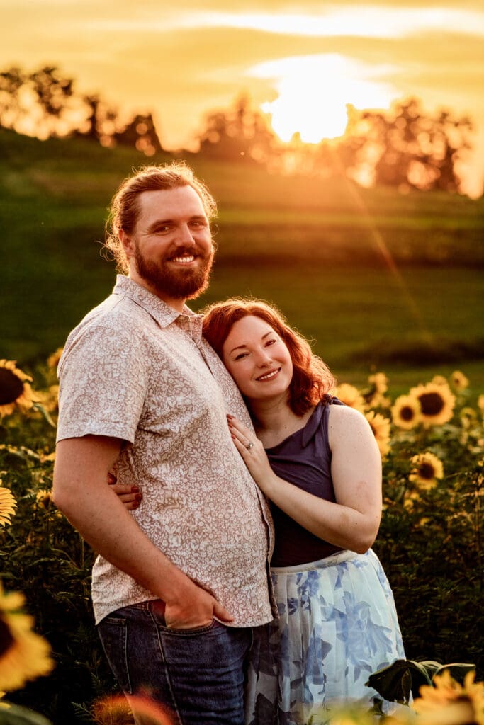 Couple sharing tender engagement moments among sunflowers during golden hour at Schwirian Sunflower Festival