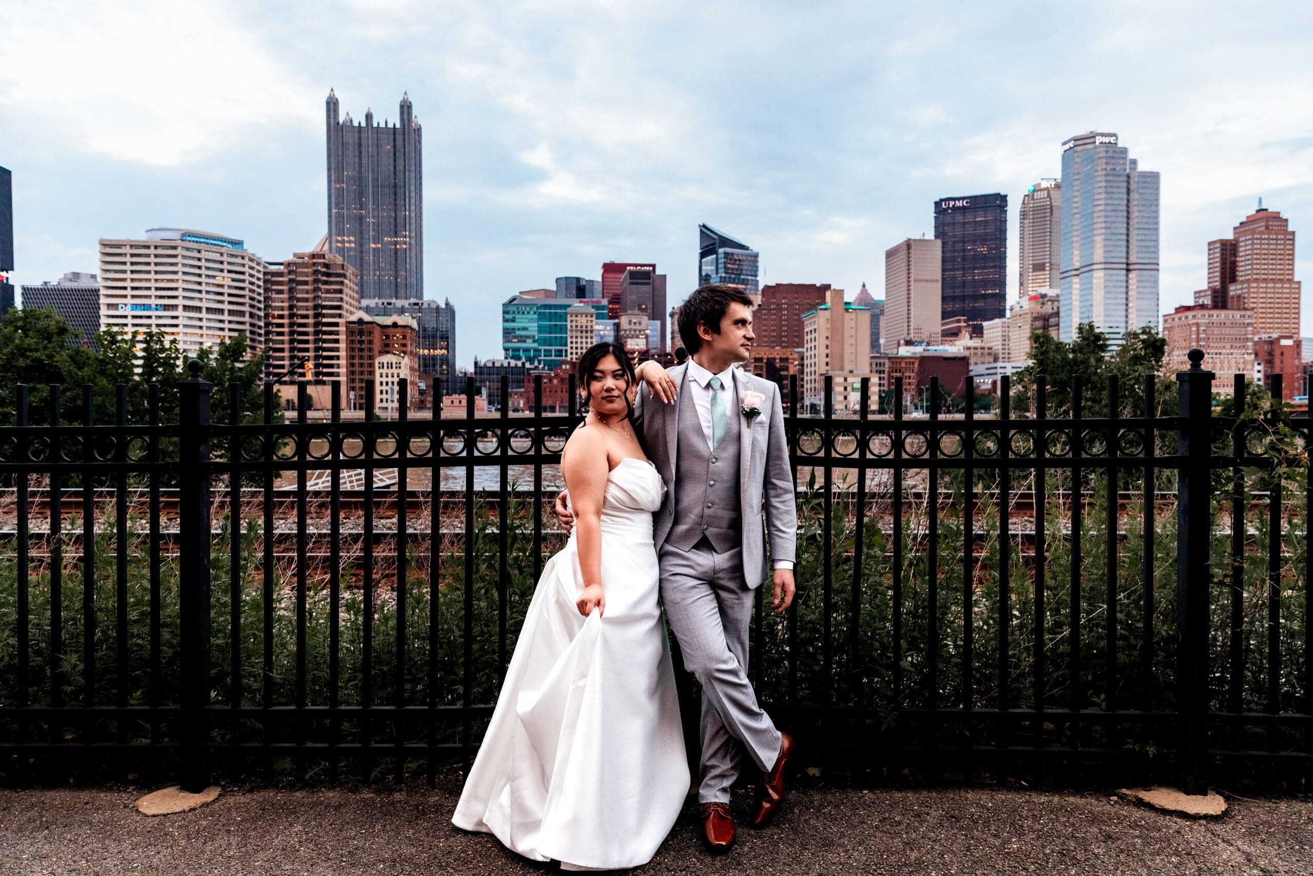 Bride and groom share a romantic moment with the Pittsburgh skyline behind them at Sheraton Station Square