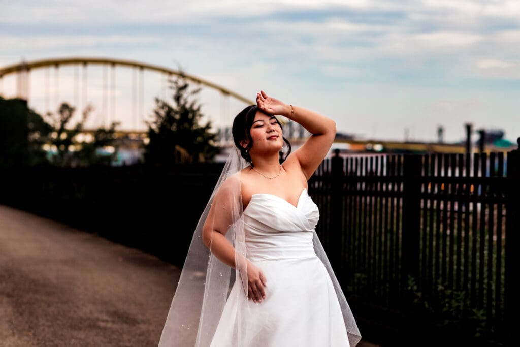 Bride poses gracefully on a paved path during wedding portraits at Sheraton Station Square