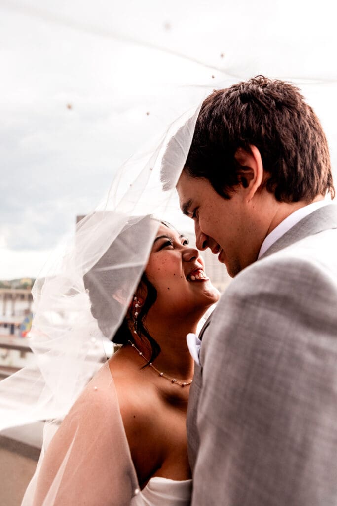 Wedding couple embraces under veil during Sheraton Station Square wedding