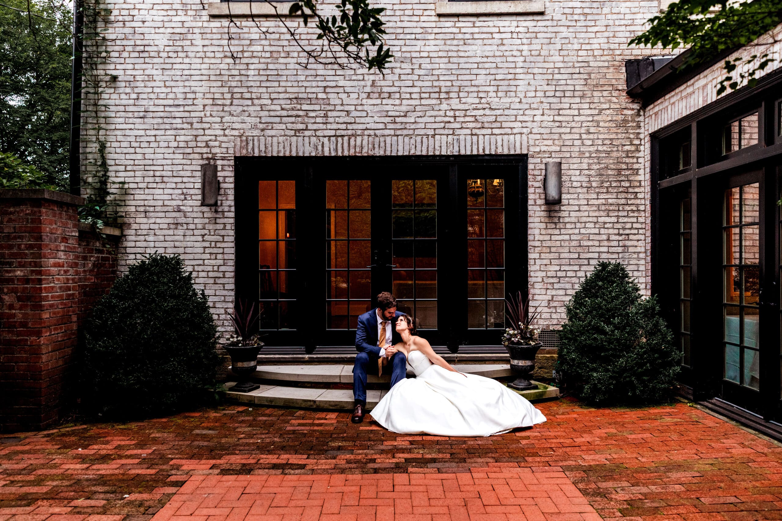 Bride and groom sitting on stairs and snuggling during wedding portraits at Succop Nature Park