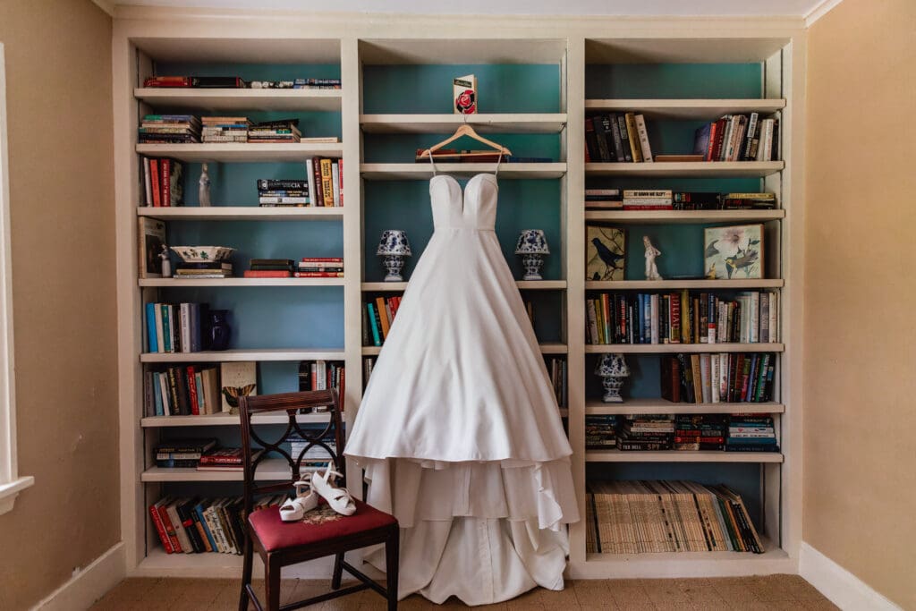 Wedding dress displayed on bookshelves during Succop Nature Park bridal prep