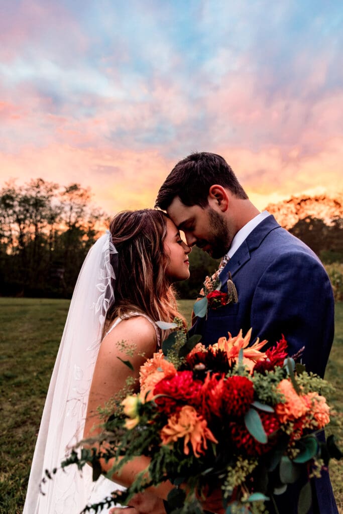 Romantic couple shares sunset moments with bold floral bouquets at Hinckston Run Farm