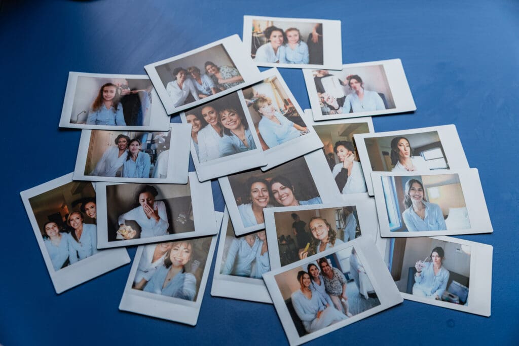 Scattered instant wedding photos arranged on blue background at National Aviary wedding