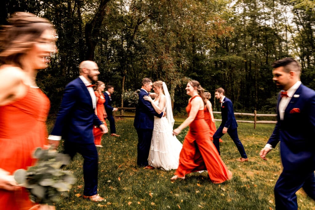Wedding party celebrating with the couple as they walk together at The Barn at Ever Thine in Butler County, PA