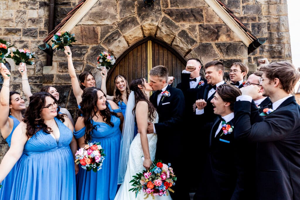 Wedding party celebrates together on stone steps at Willowbrook