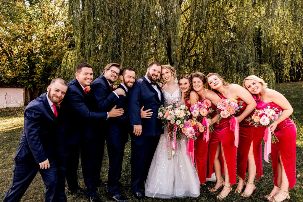Bridal party posing together under a willow tree at The Gathering Place at Darlington Lake wedding