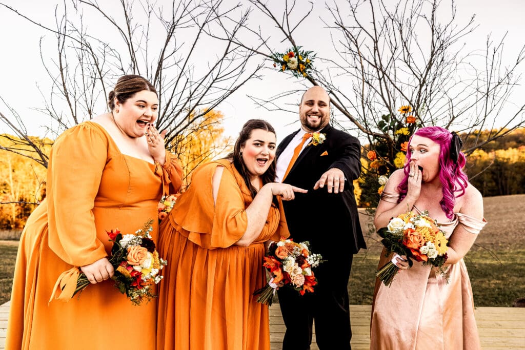Bridesmaids admiring the groom’s ring during portraits at fall Ridgemont Farm wedding in Beaver County