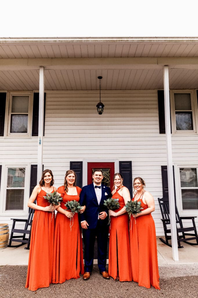 Groom posing with bridesmaids during wedding portraits at The Barn at Ever Thine in Fenelton, PA