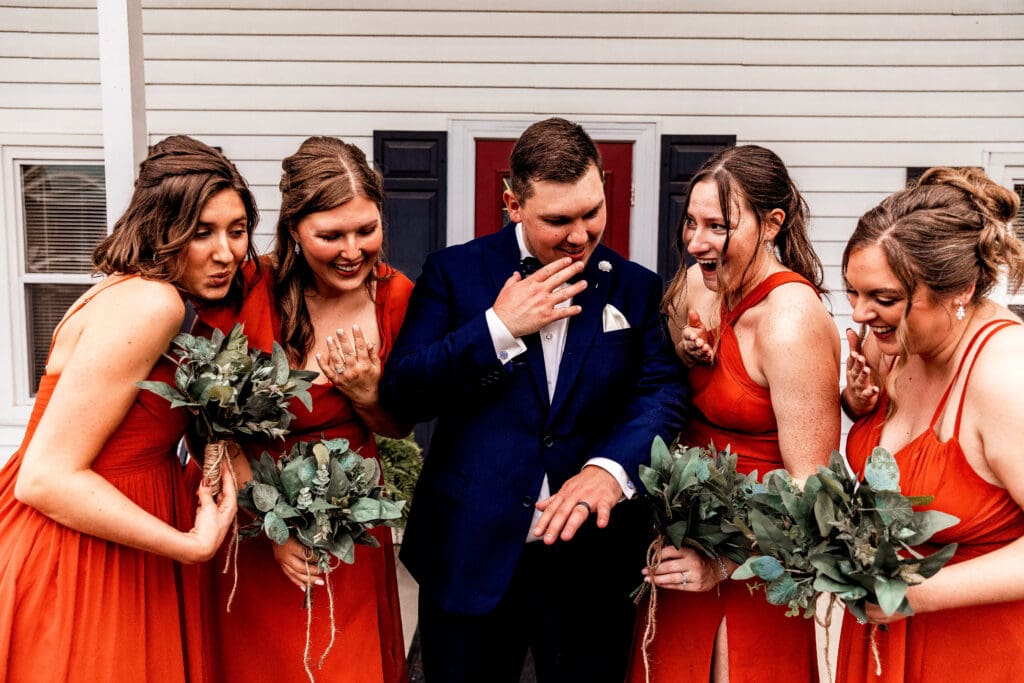 Groom and bridesmaids admiring the wedding ring during portraits at The Barn at Ever Thine in Butler County, Pennsylvania