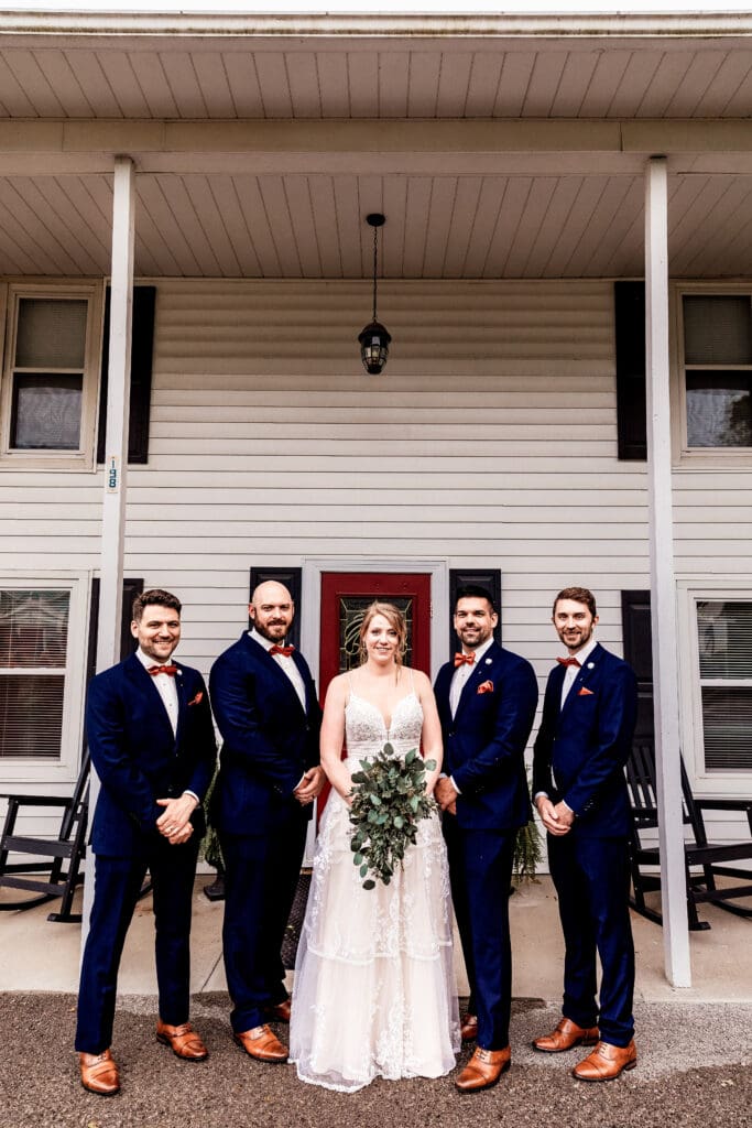 Bride and groomsmen smiling together during wedding portraits at The Barn at Ever Thine in Butler County, PA