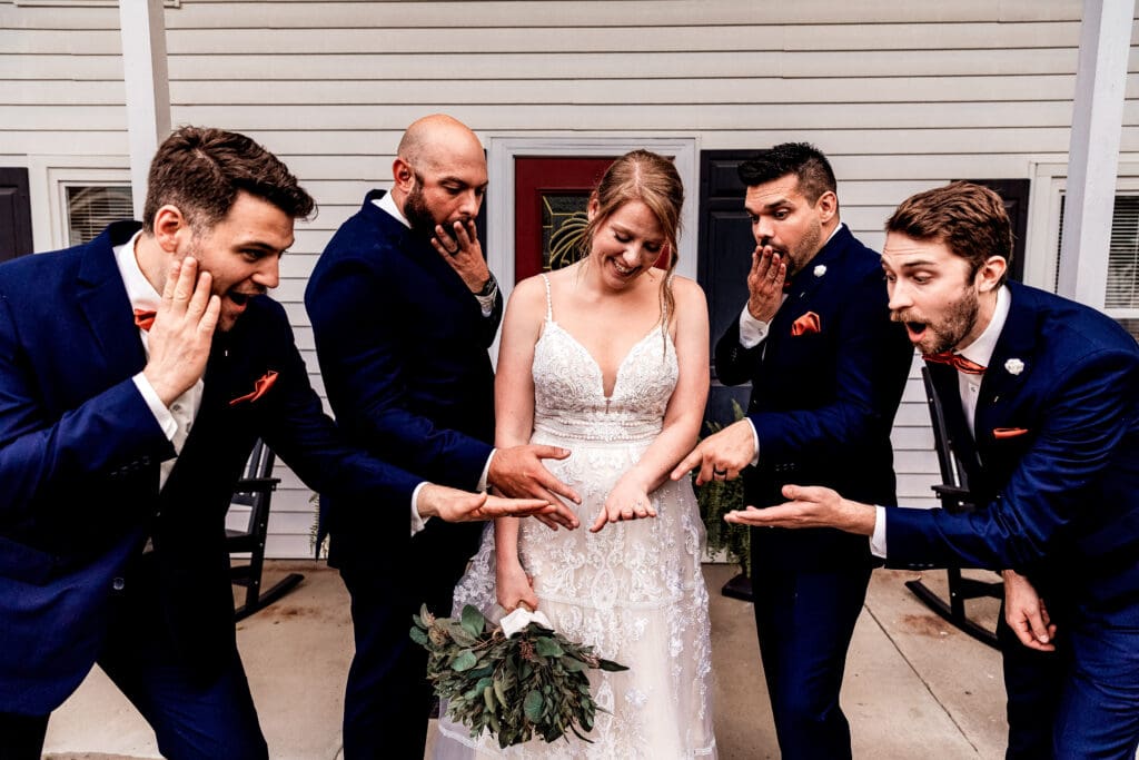 Bride and groomsmen admiring the engagement ring during wedding portraits at The Barn at Ever Thine in Fenelton, PA