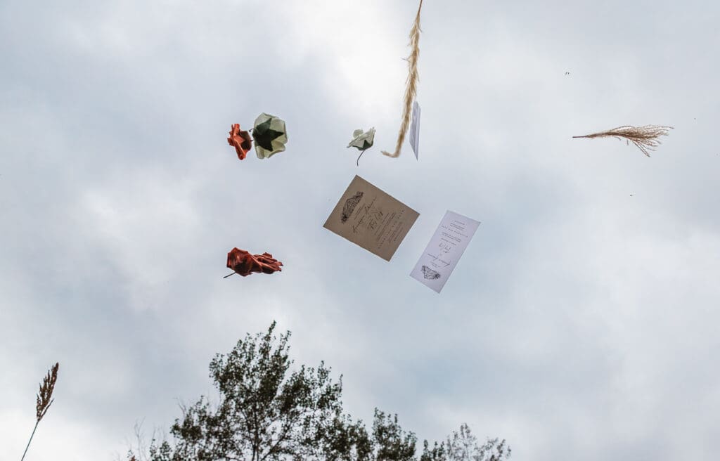 Wedding details cascading through the air during creative photo moment at Hinckston Run Farm