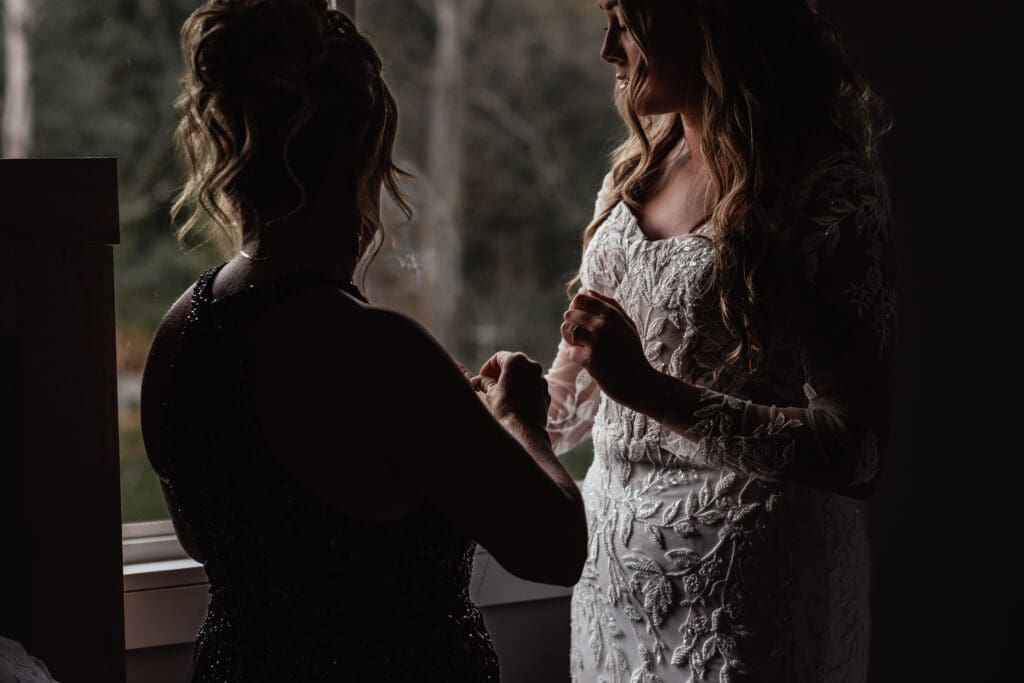 Mother helping bride put on bracelet while getting ready at Hinckston Run Farm wedding