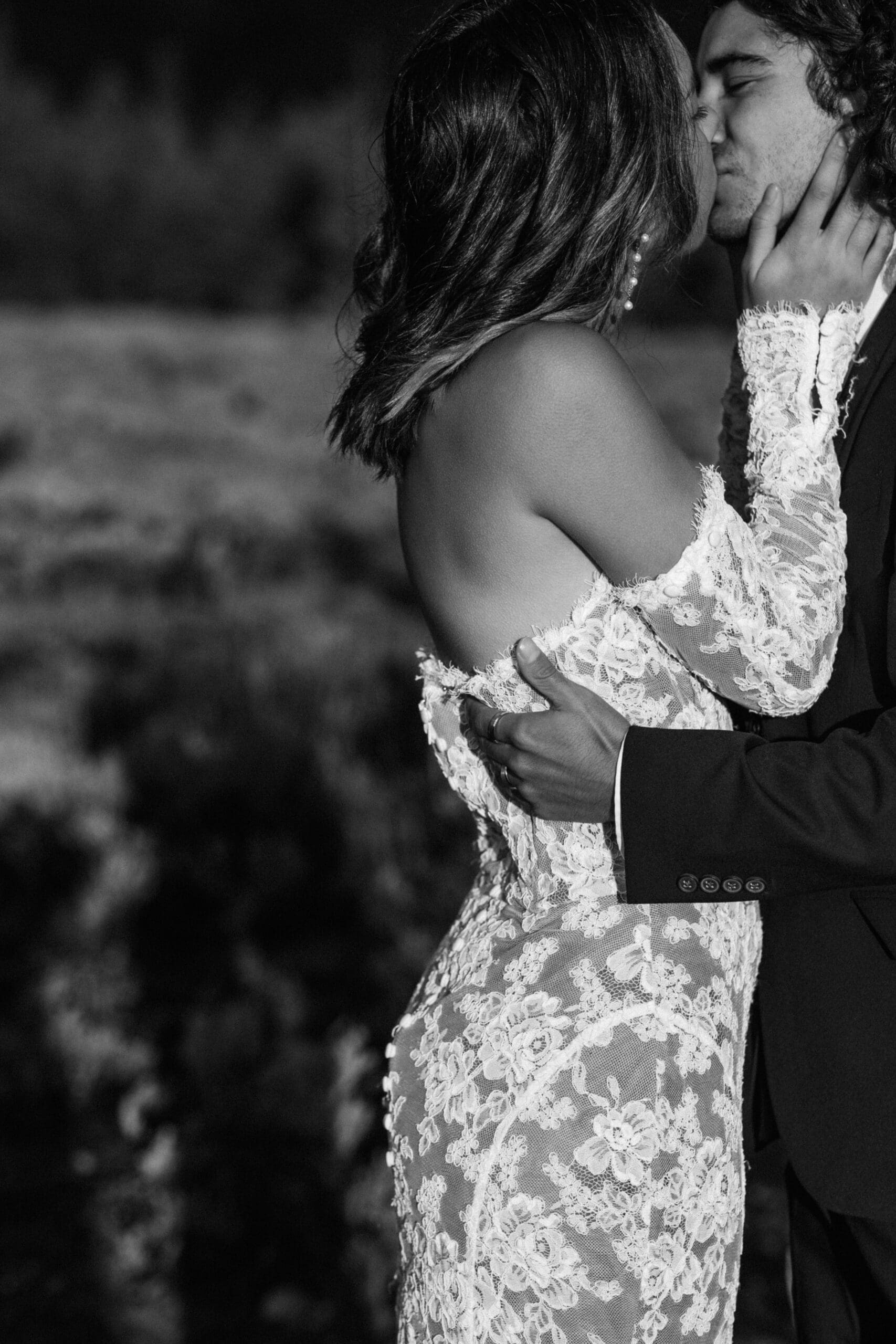 Close-up of an eloping couple’s hands intertwined as they lean in to kiss during their mountain elopement.