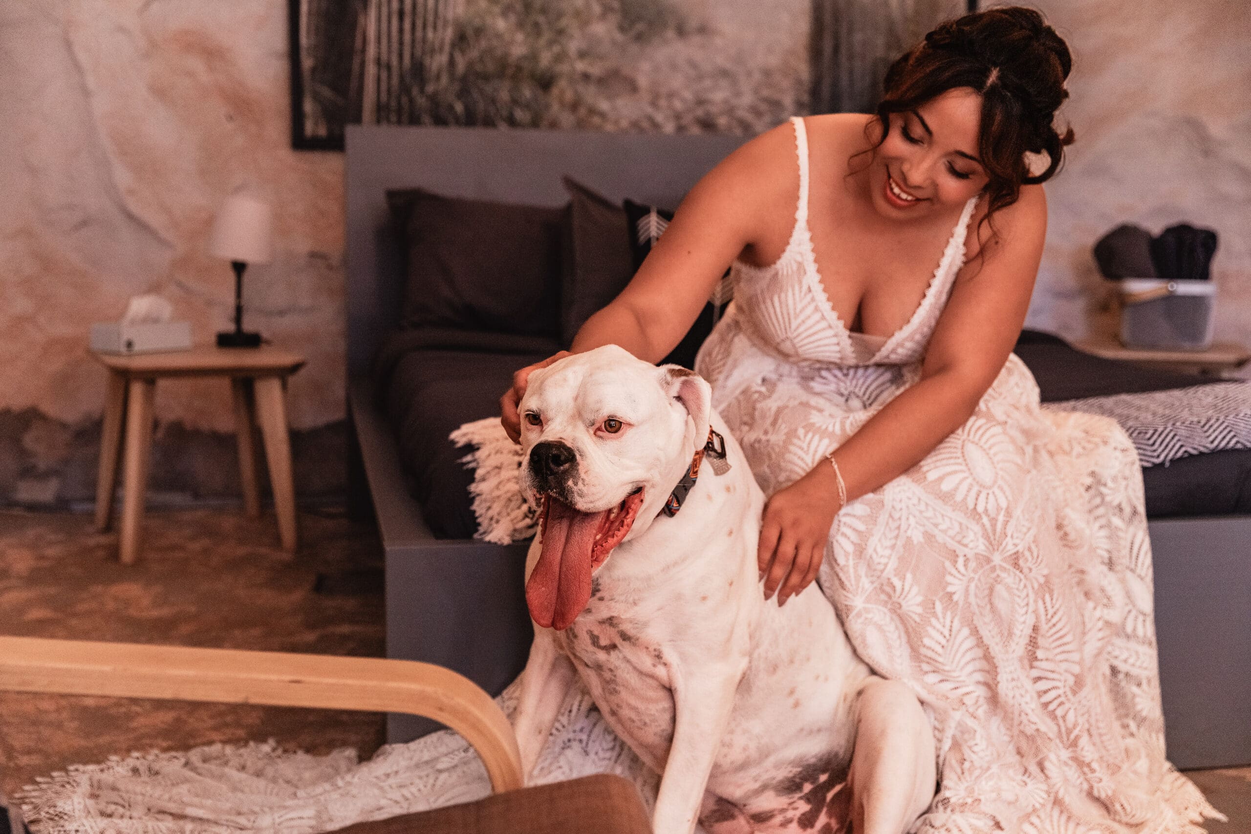 Bride finishing getting ready in a cave desert Airbnb before her dog-friendly Moab elopement, soft window light highlighting quiet pre-ceremony moments.