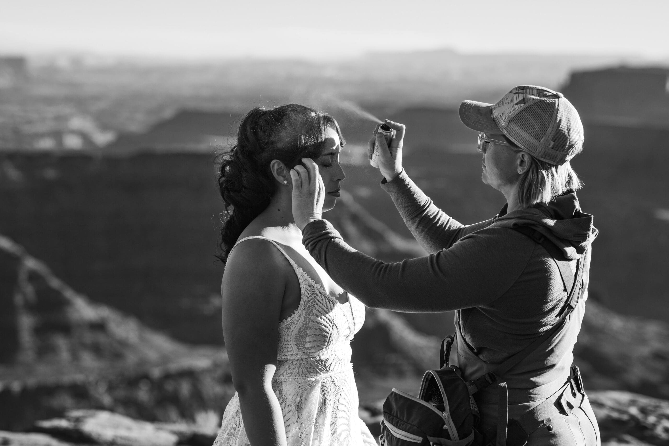 Hair stylist and makeup artist putting the finishing touches on the bride’s hair and makeup at Marlboro Point during a Moab adventure elopement.