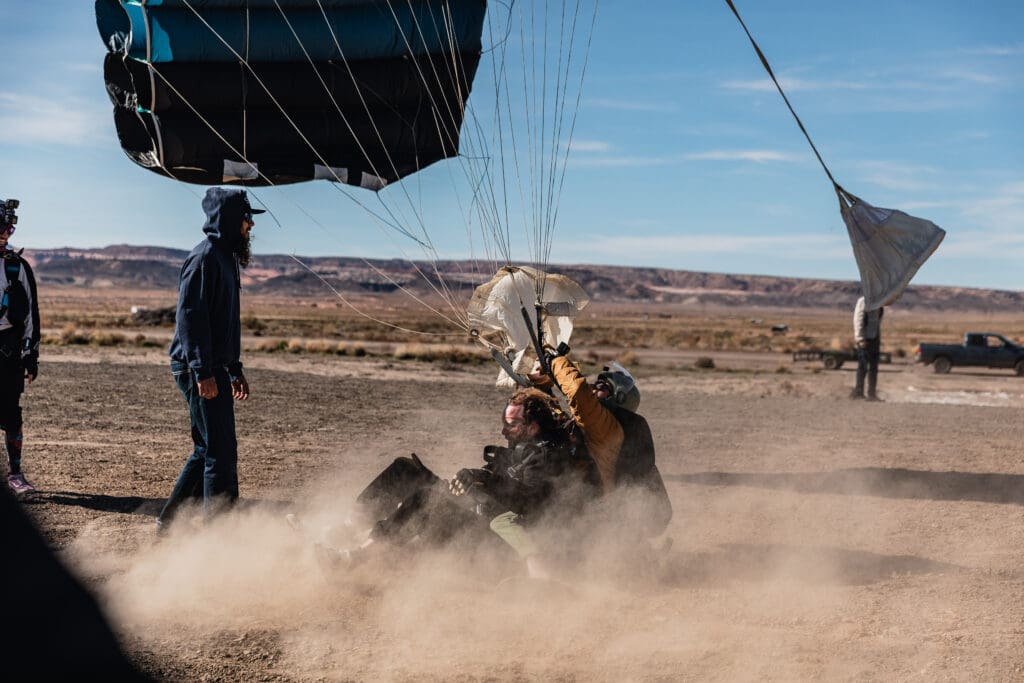 Groom landing on the drop zone after completing a tandem skydive as part of the couple’s unique elopement experience.