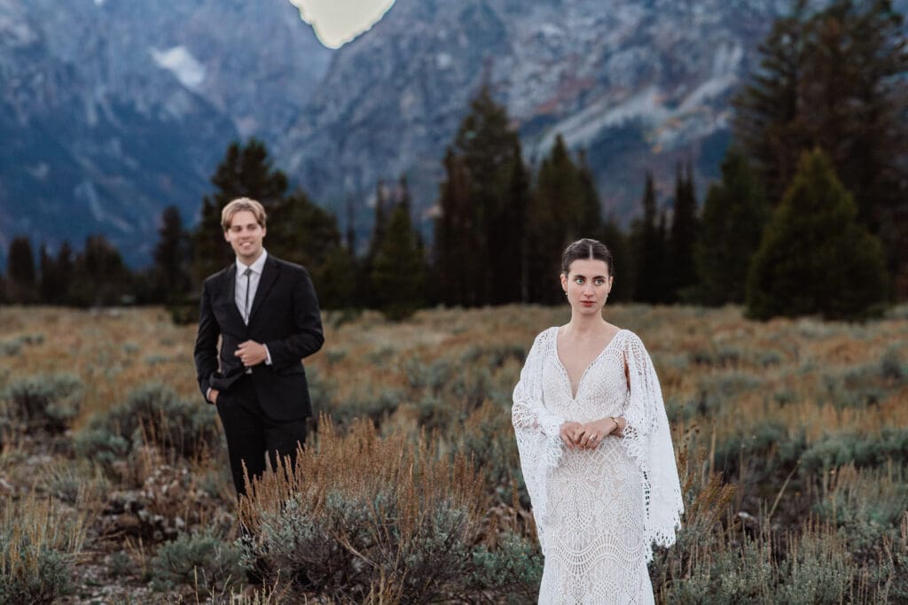 Eloping couple standing together for a portrait with the iconic Teton mountain range stretching across the background.