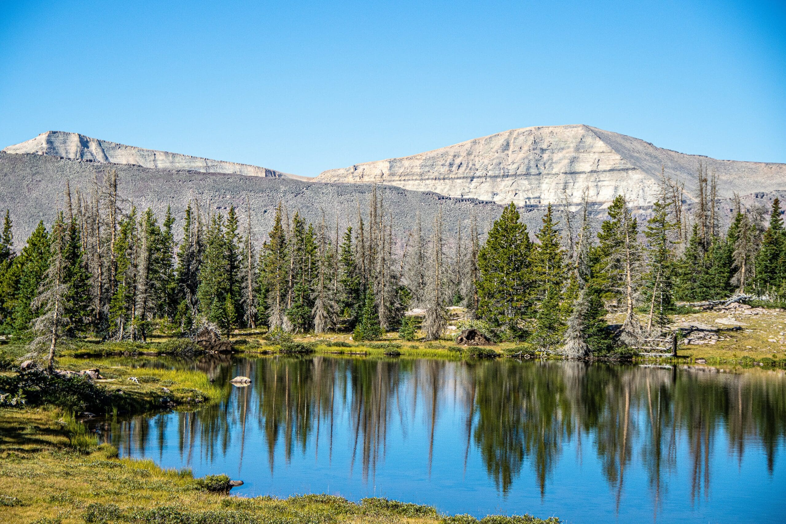 Still waters reflecting mountain peaks at Mirror Lake in the Uinta Mountains