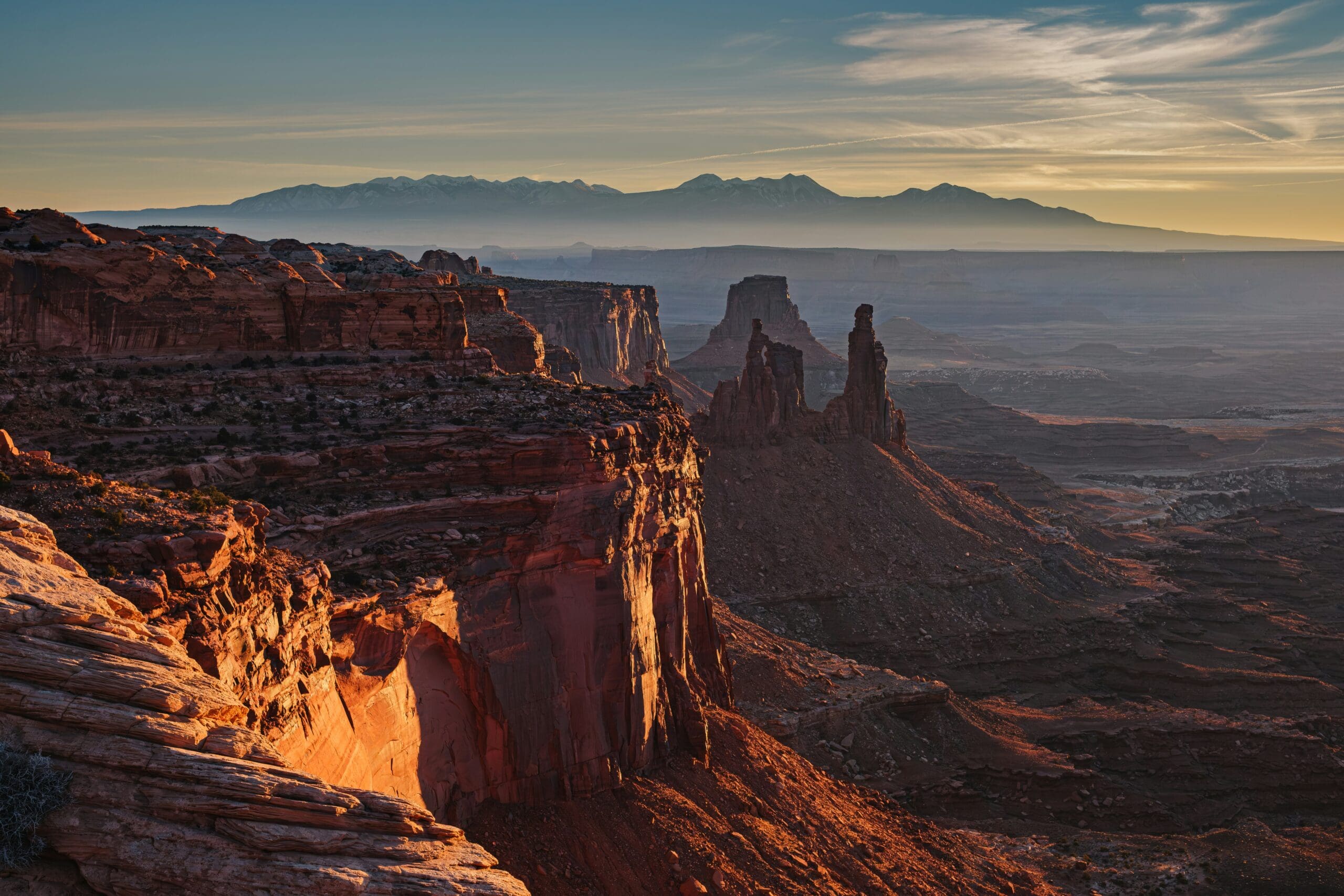 Golden sunset light over the canyons and mesas of Canyonlands National Park with dramatic desert shadows and glowing sky.
