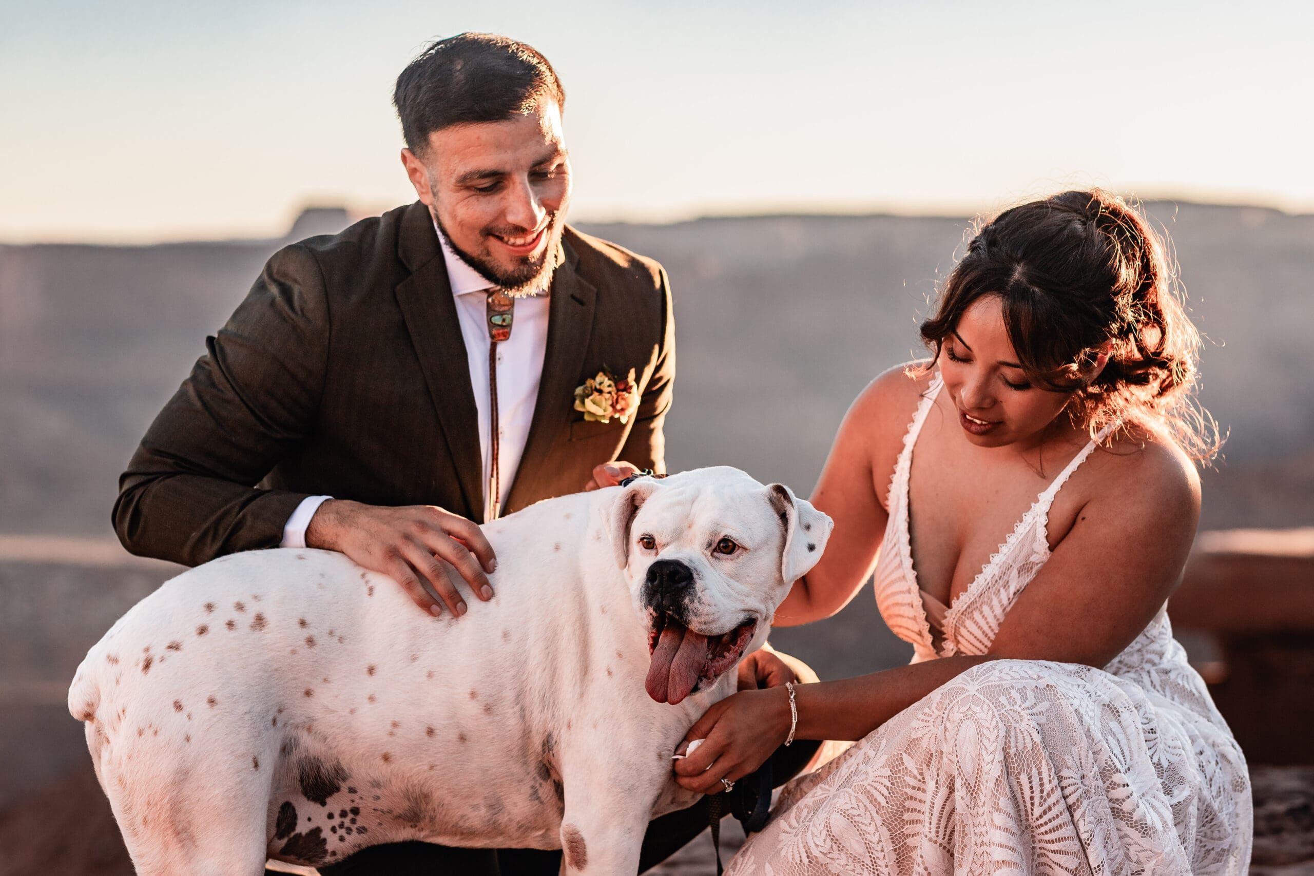 Close-up of a dog being pet by their owners after their Moab elopement ceremony showing a quiet, emotional moment together
