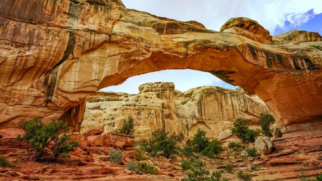 Natural sandstone arch bridge formation in Capitol Reef National Park desert landscape